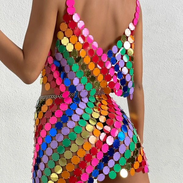 Close-up of a model wearing a multicolored, open-back sequin mini dress