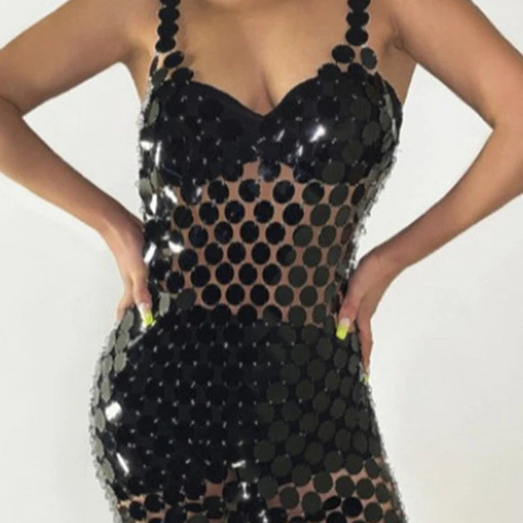 Cropped model wearing a black sequin dress with a sheer polka-dot mesh midsection