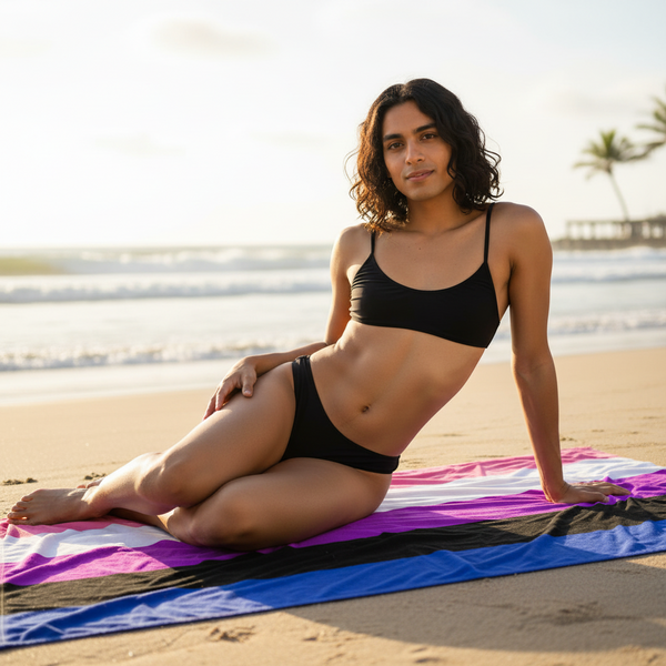 Genderfluid Pride Flag towel with crisp pink, white, purple, black, and blue stripes; queer femme lounges by the ocean.