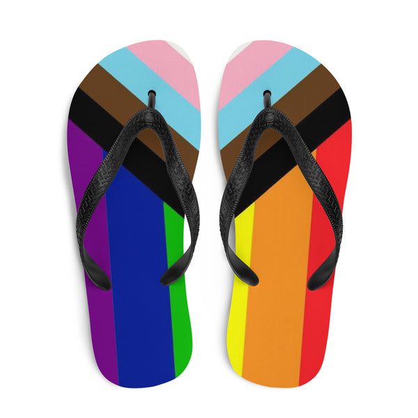 LGBT Pride Progress Flip-Flops featuring vibrant rainbow footbeds, inclusive of trans, black, and brown stripes. Black rubber straps offer comfort and style, embodying queer empowerment and visibility for adventurous, prideful self-expression.