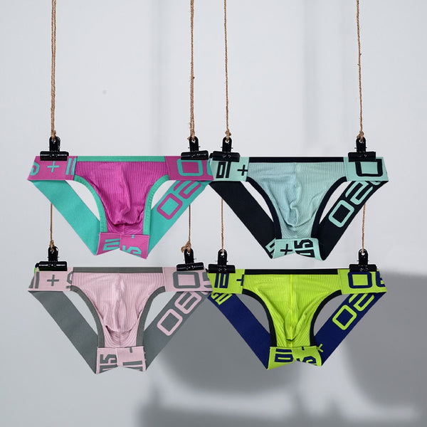 Four colorful jockstraps hanging in two rows, with geometric patterned waistbands