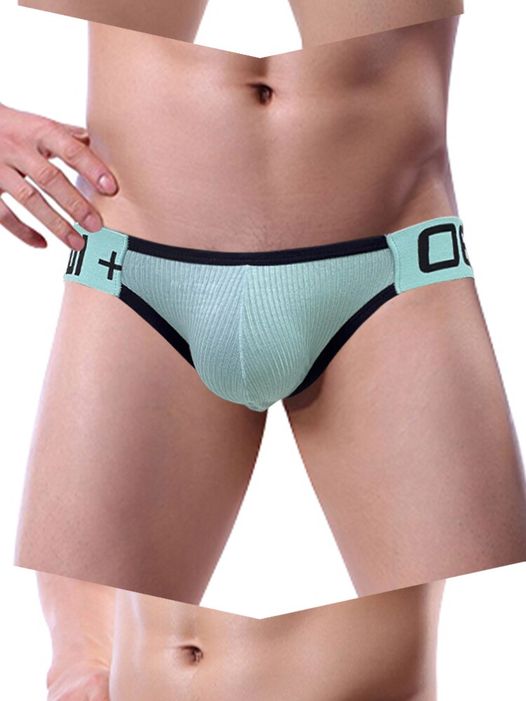 Front view of a model wearing a mint ribbed jockstrap with black trim and waistband symbols