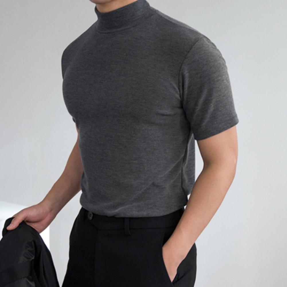Cropped front view of a person wearing a fitted charcoal-gray mock-neck T-shirt and black trousers