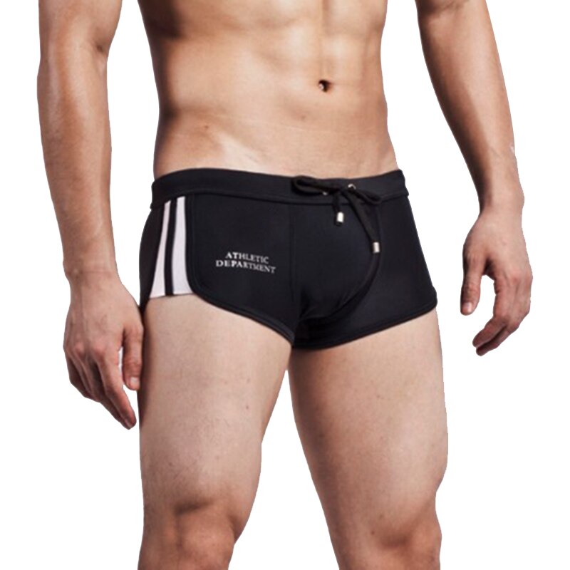 Front-view model wearing black boxer-style swim trunks with white side stripes and drawstring