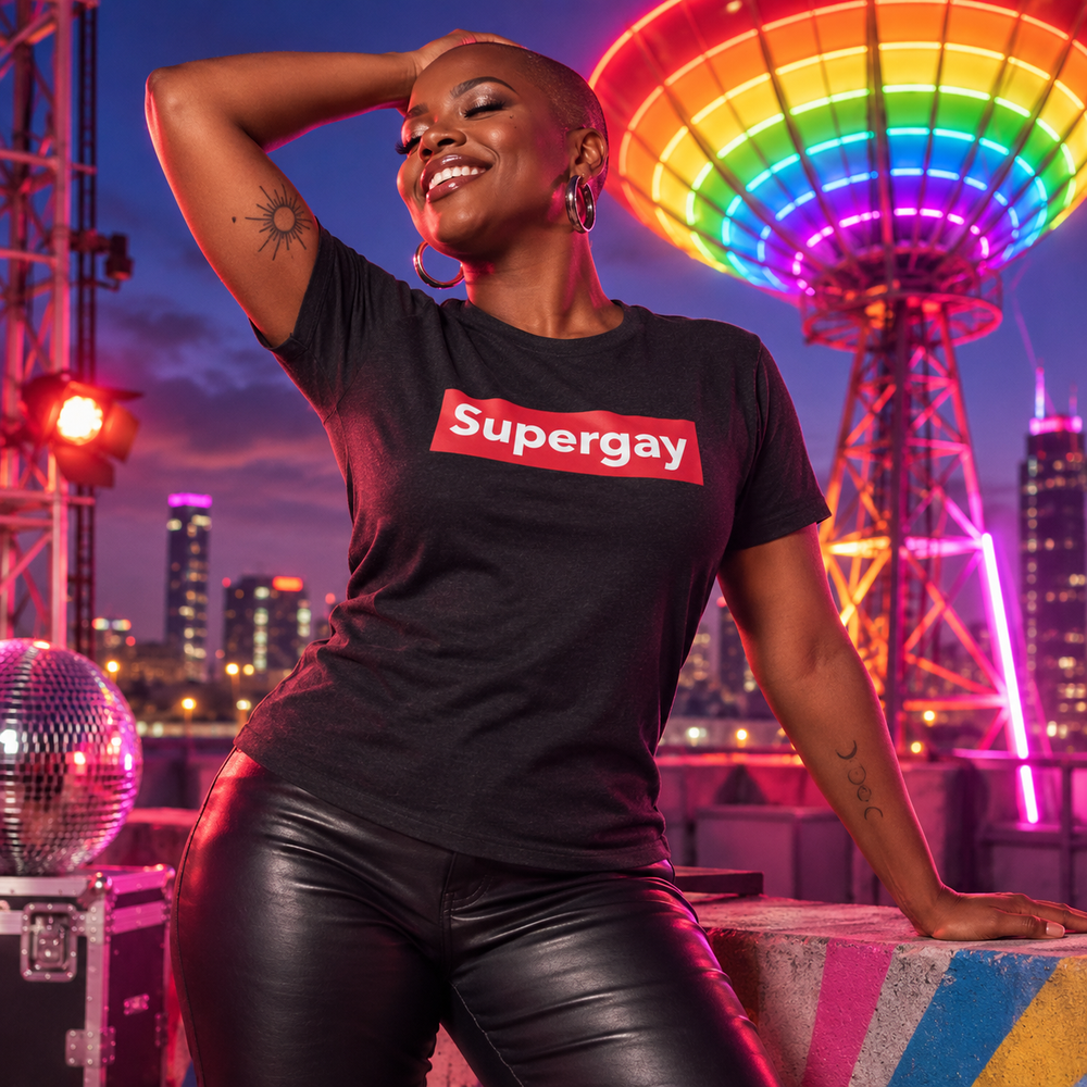 Supergay black heather T-shirt with bold red and white logo at a theatrical rainbow rooftop broadcast tower
