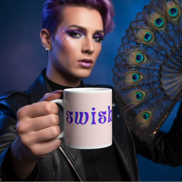 Person in a black leather jacket holds a pale pink mug reading “swish,” with a peacock fan behind them