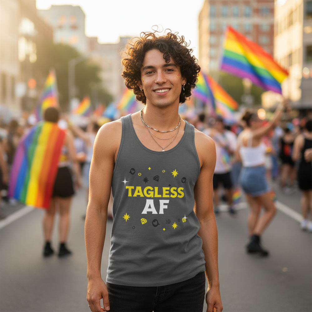 Smiling person models a gray tank top reading “TAGLESS AF” at a Pride parade