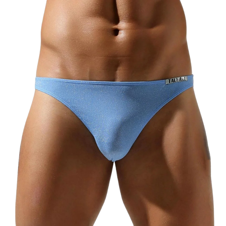 Front view of a model wearing light blue metallic-finish briefs with a Tauwell waistband label