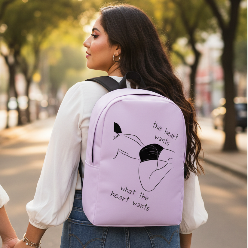 Minimalist light purple backpack reads “The Heart Wants What The Heart Wants” with a reclining figure