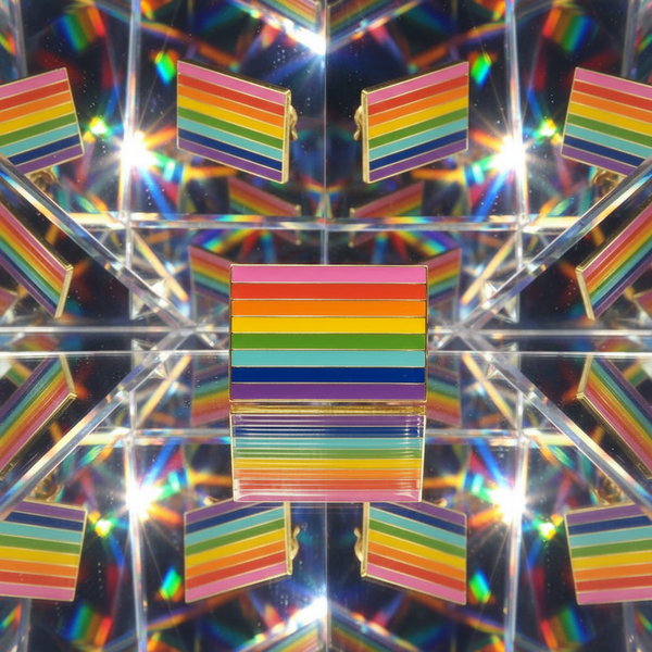 Rainbow LGBT Pride enamel pin displayed against mirrored reflections