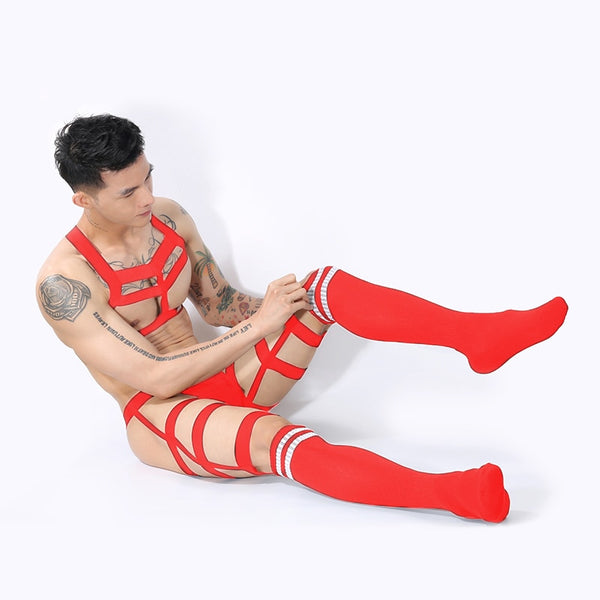 Model wearing a red elastic chest harness, briefs, and striped thigh-high socks