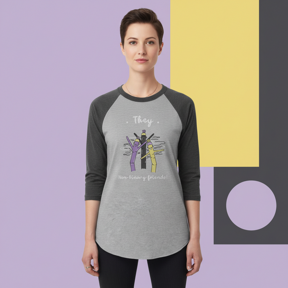 Front view of a model wearing a gray raglan shirt reading “They” and “Non-binary friends!”