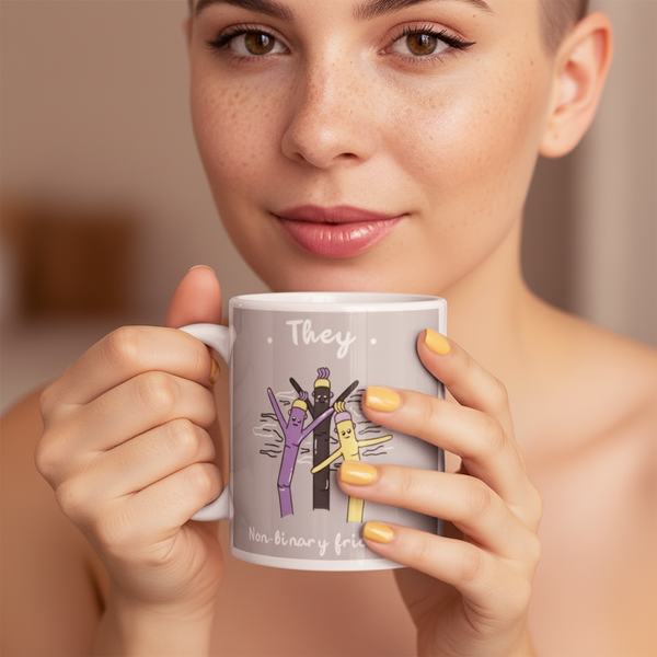 White mug held in front of a person's face, labeled “They” with colorful cartoon figures