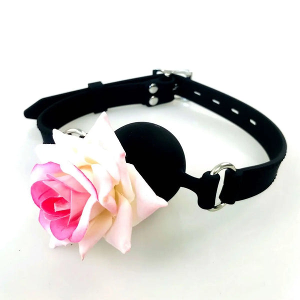 Black leather ball gag with a pink-and-white rose detail, shown at an angle on white
