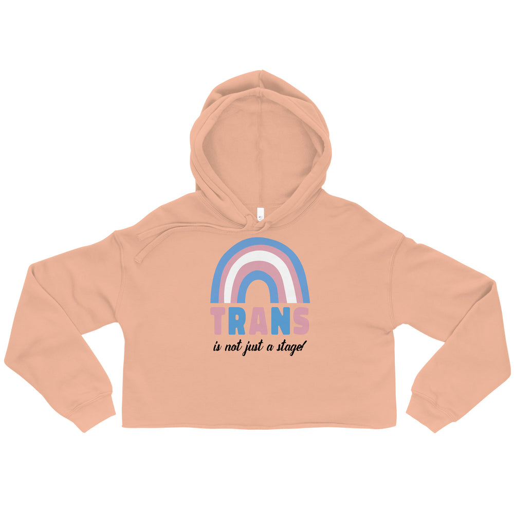 Front view of a peach cropped hoodie with a rainbow and “TRANS is not just a stage” graphic