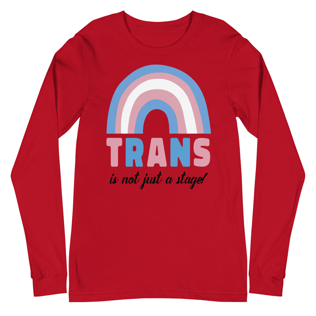 Front view of a red long-sleeve shirt with a pastel rainbow and “TRANS is not just a stage!”