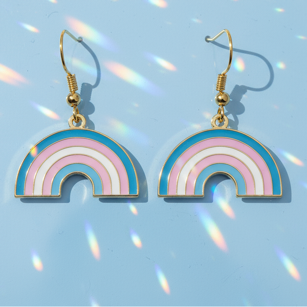 Gold-tone trans pride rainbow dangle earrings with pink, white, and blue enamel arches