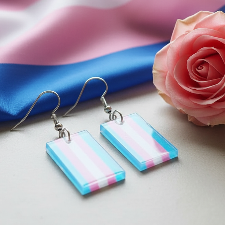 Pair of rectangular blue, pink, and white striped dangle earrings beside a pink rose