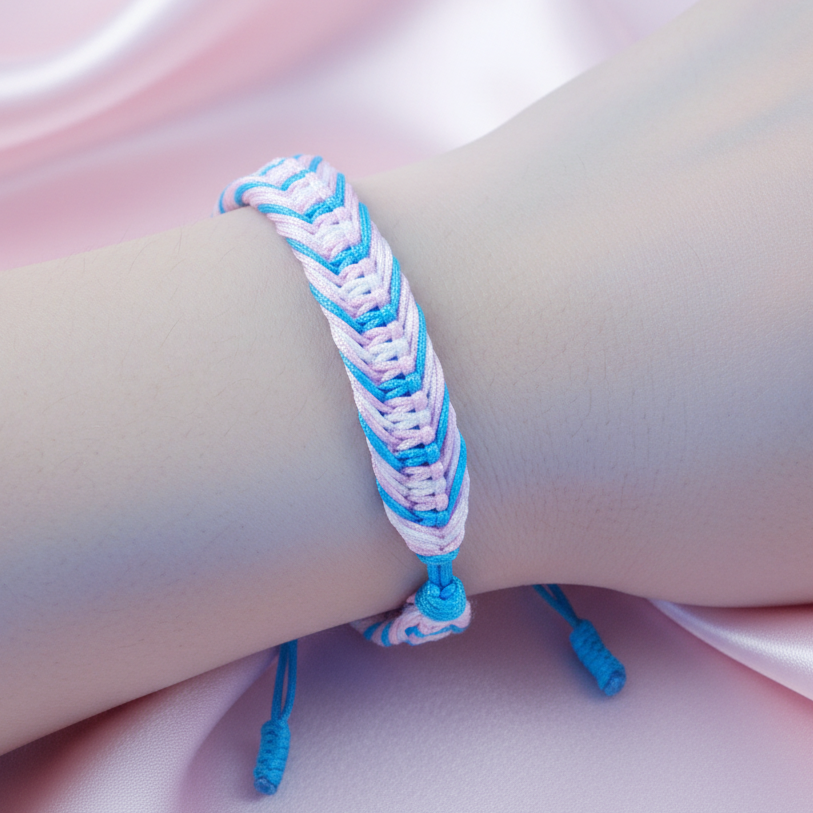 Close-up of a pastel pink, white, and blue braided bracelet on a wrist