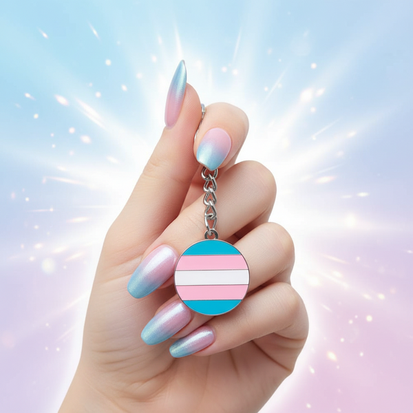 Transgender pride circle keychain with pink, blue, and white flag stripes, held by a hand