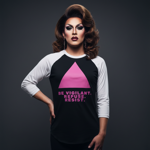 3/4 sleeve raglan shirt with bold pink triangle and “Be Vigilant. Refuse. Resist.”, worn by a drag queen facing the camera.
