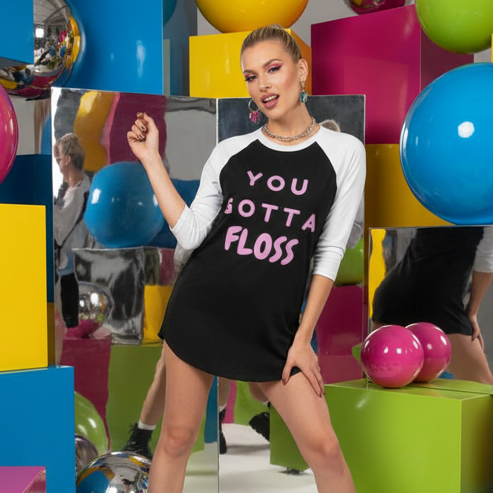 Model wearing a black-and-white raglan shirt reading “YOU GOTTA FLOSS”