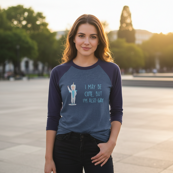 Cute But Gay 3/4 sleeve raglan shirt with cartoon and “I may be cute, but I'm also gay”, worn at sunset by a smiling woman.