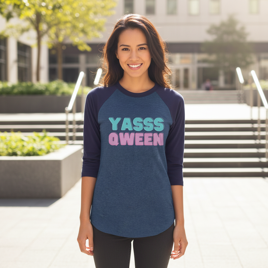 Yasss Queen 3/4 sleeve raglan shirt with navy sleeves, pastel "YASSS QWEEN" slogan; woman smiling outdoors in sunlight.