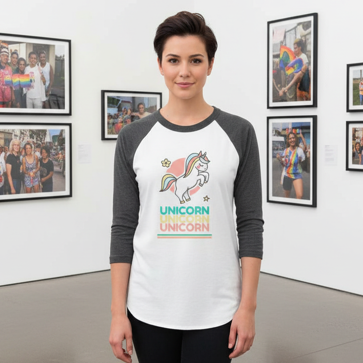 Model wearing a white-and-charcoal raglan shirt with a unicorn and repeated UNICORN text