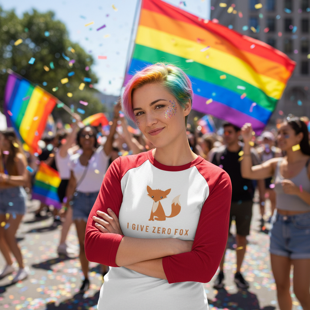 3/4 sleeve raglan shirt reading "I Give Zero Fox," worn by a proud queer person with rainbow hair at a vibrant pride parade.