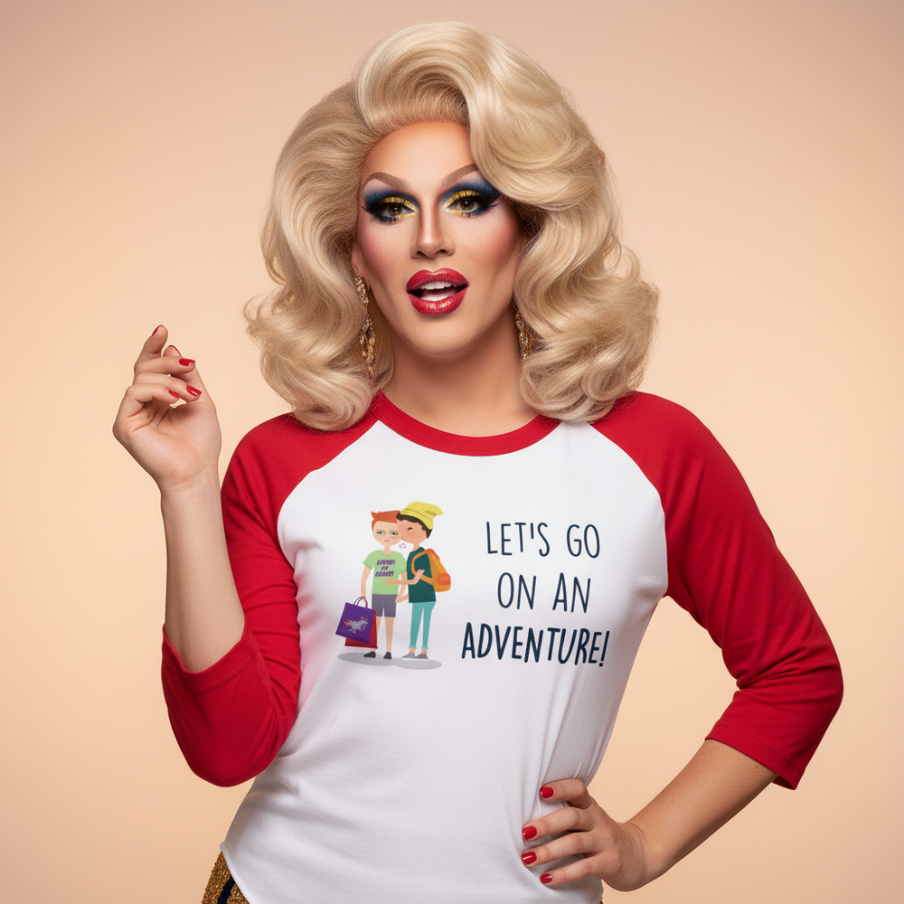 3/4 sleeve raglan shirt with bold “LETS GO ON AN ADVENTURE!” slogan, worn confidently by a drag queen with blonde hair.