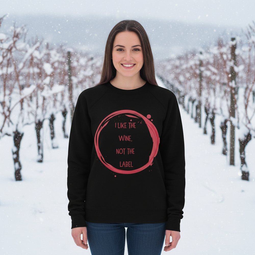 Black sweatshirt with pink “I LIKE THE WINE, NOT THE LABEL” graphic, worn in a snowy vineyard