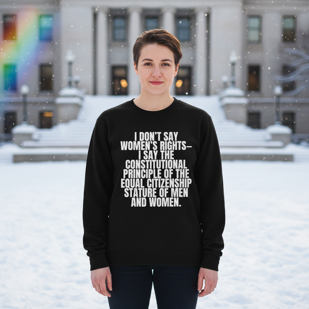 Black sweatshirt with “I DON’T SAY WOMEN’S RIGHTS—” slogan, worn outdoors in falling snow