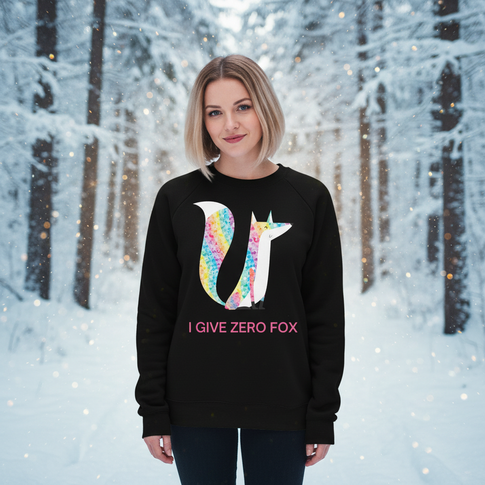 In a snowy forest, a model wears a black sweatshirt with a colorful fox and “I GIVE ZERO FOX” text