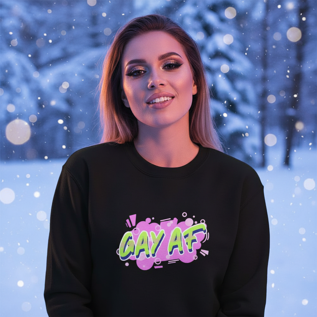 Person wearing a black sweatshirt with colorful “GAY AF” graffiti lettering in falling snow
