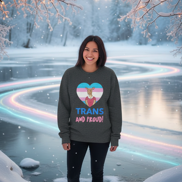 Smiling model wears a dark sweatshirt reading “TRANS AND PROUD!” beside a snowy, rainbow-lit lake