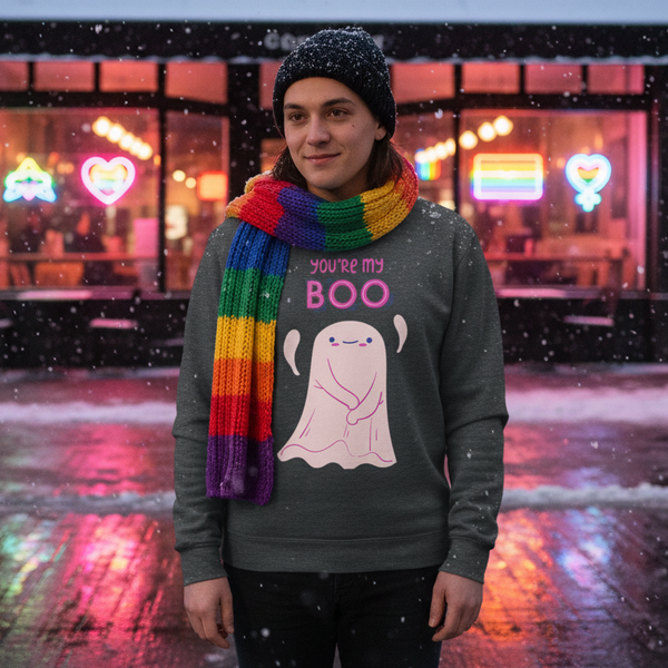 Front-facing person wearing a dark sweatshirt reading “YOU’RE MY BOO” with a ghost graphic in falling snow