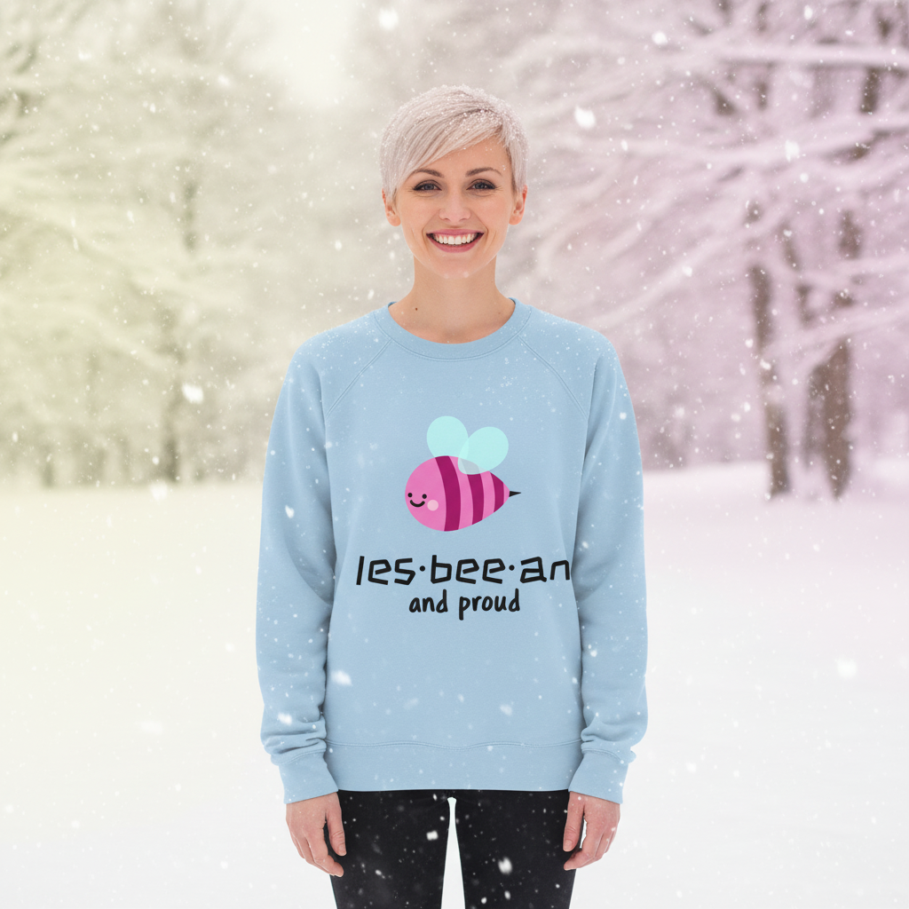 Person in snowfall wearing a light-blue Les-bee-an And Proud Unisex Sweatshirt with stylized bee design, smiling confidently, representing LGBTQ pride and self-expression.