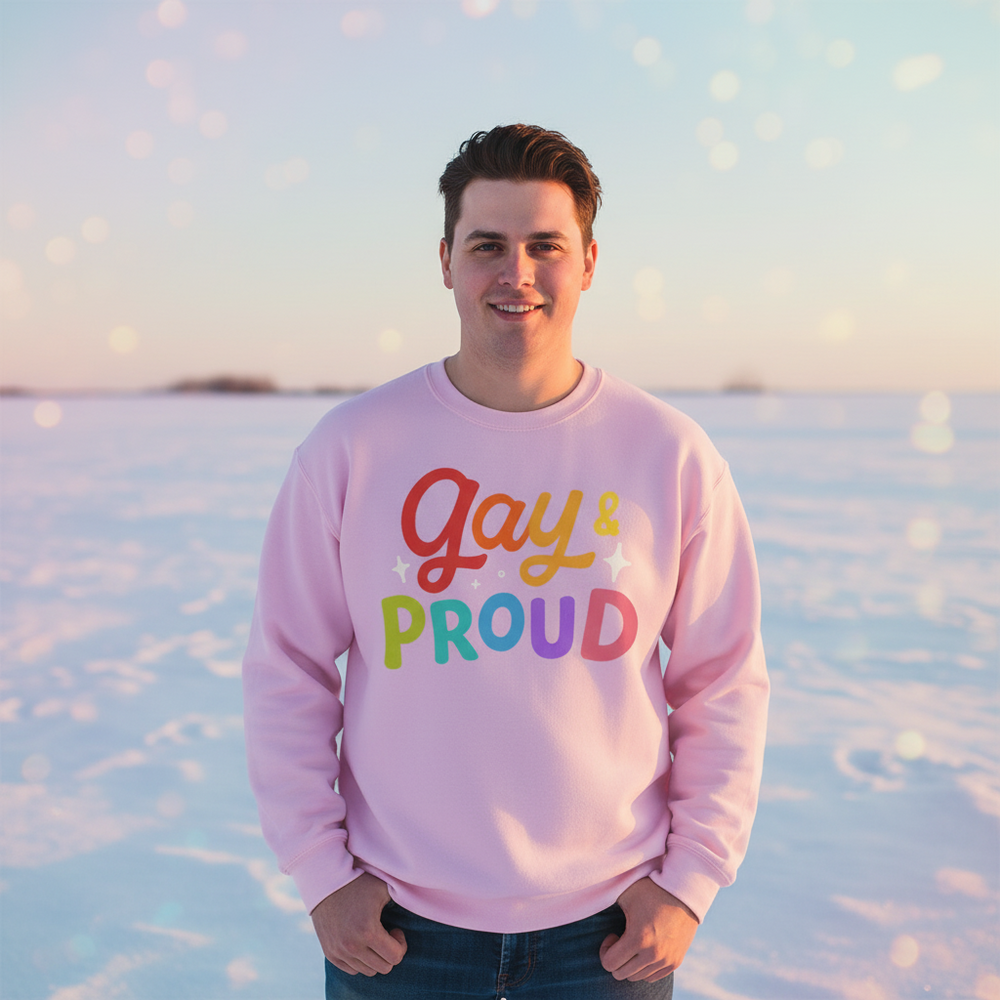 Front-facing person wearing a pink sweatshirt reading “Gay & Proud” in a snowy landscape