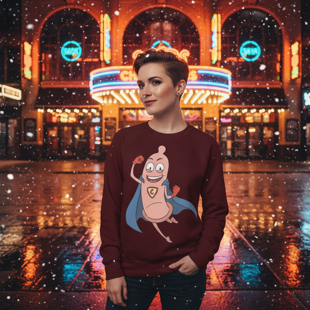 Person wearing a burgundy sweatshirt with a smiling superhero condom graphic outside a neon-lit theater