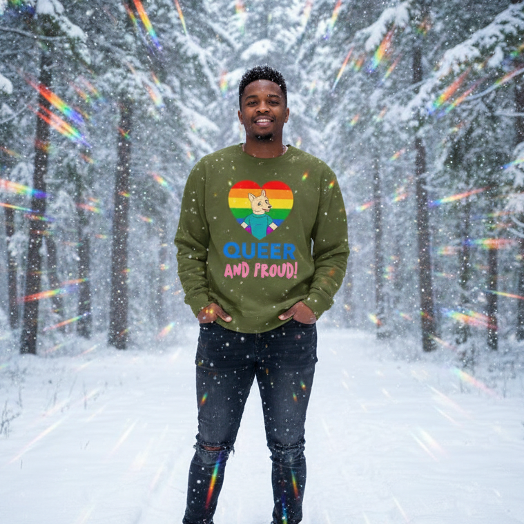 Person wearing an olive sweatshirt with a rainbow heart, fox, and “QUEER AND PROUD!” text in a snowy forest