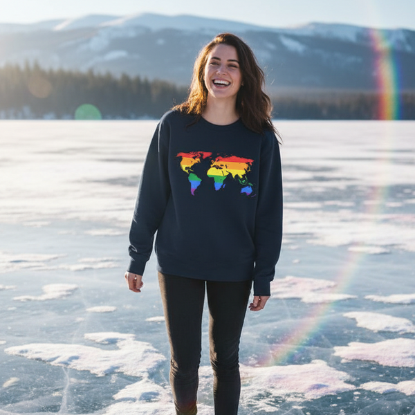 Smiling person in a dark sweatshirt with a rainbow world map, standing on a frozen lake