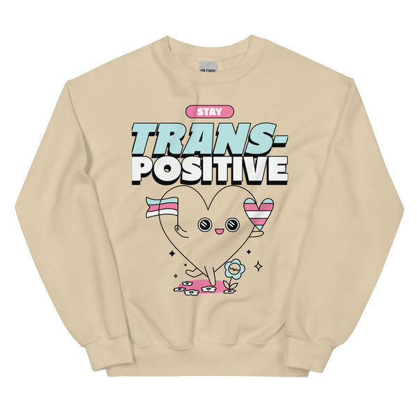 Unisex sweatshirt featuring a heart character with trans pride flags, flowers, sparkles, hearts, and bold “STAY TRANS-POSITIVE” text.