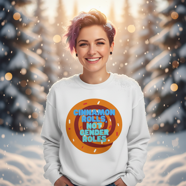 Person wearing a white sweatshirt reading “CINNAMON ROLLS NOT GENDER ROLES” in a snowy forest