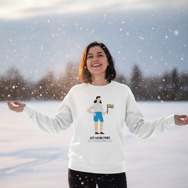 Person outdoors in falling snow wearing a white sweatshirt reading “LET US BE FREE LET US BE PROUD.”