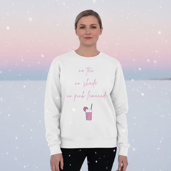 Front-facing model in a white sweatshirt reading “no tea no shade no pink lemonade” with a pink drink graphic