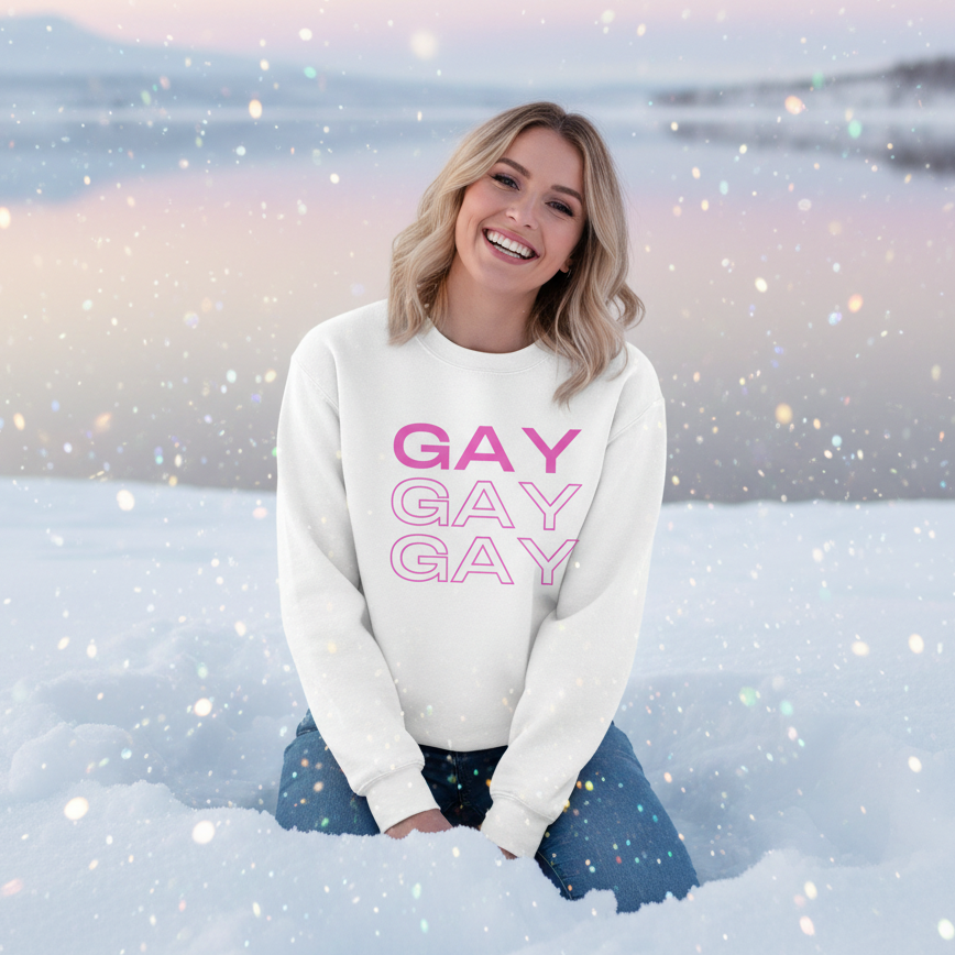 Smiling person in snow, near a frozen lake at sunset, wearing a Gay Gay Gay Unisex Sweatshirt. The white sweatshirt with pink lettering embodies joyful queer pride and self-expression.