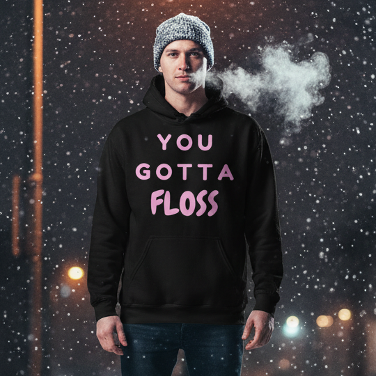 Young man in falling snow wears the You Gotta Floss Unisex Hoodie, showcasing bold pink lettering and a cozy design perfect for expressing pride and confidence in cooler weather.