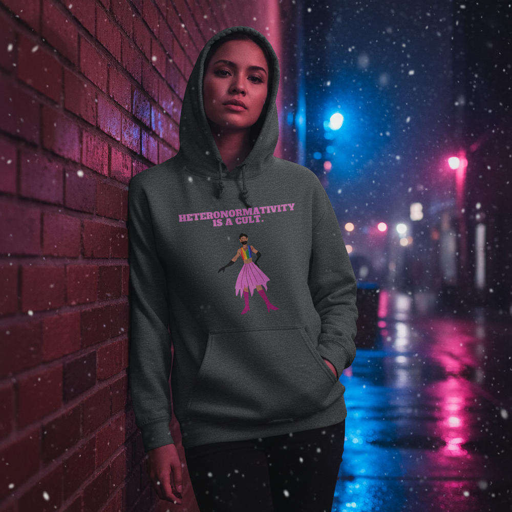 Person modeling a dark hoodie reading “HETERONORMATIVITY IS A CULT.” in a snowy neon alley