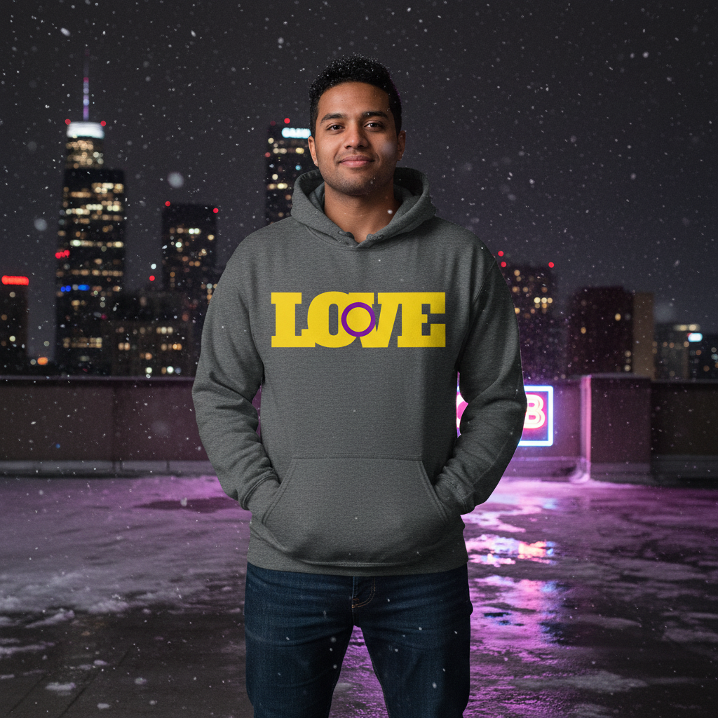 Young man in Intersex Love Unisex Hoodie with bold LOVE print stands on a snowy rooftop at night, city lights behind him. The cozy, stylish hoodie exudes warmth, pride, and self-expression.